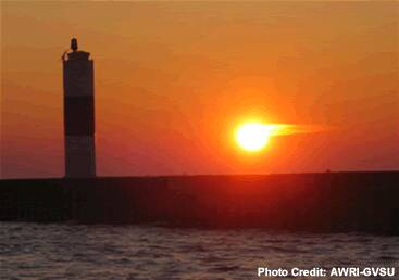 The Muskegon Pier lighthouse silhouetted at sunset.